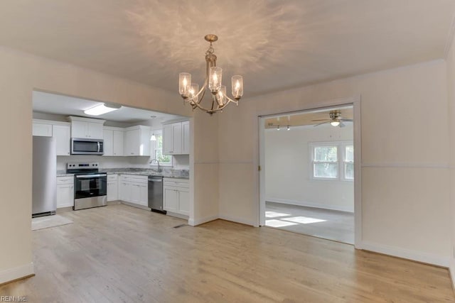 kitchen featuring ceiling fan with notable chandelier, white cabinets, stainless steel appliances, and light wood-type flooring