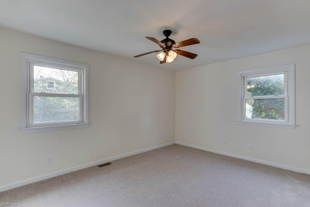 empty room with carpet, a healthy amount of sunlight, and ceiling fan