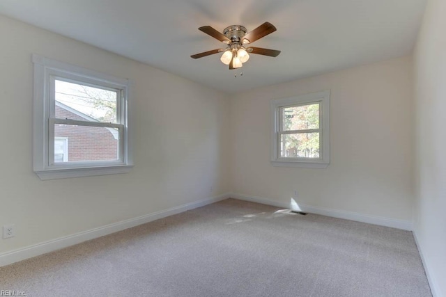 spare room with ceiling fan, light colored carpet, and a healthy amount of sunlight