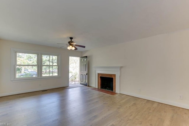 unfurnished living room with ceiling fan, light hardwood / wood-style floors, and a fireplace