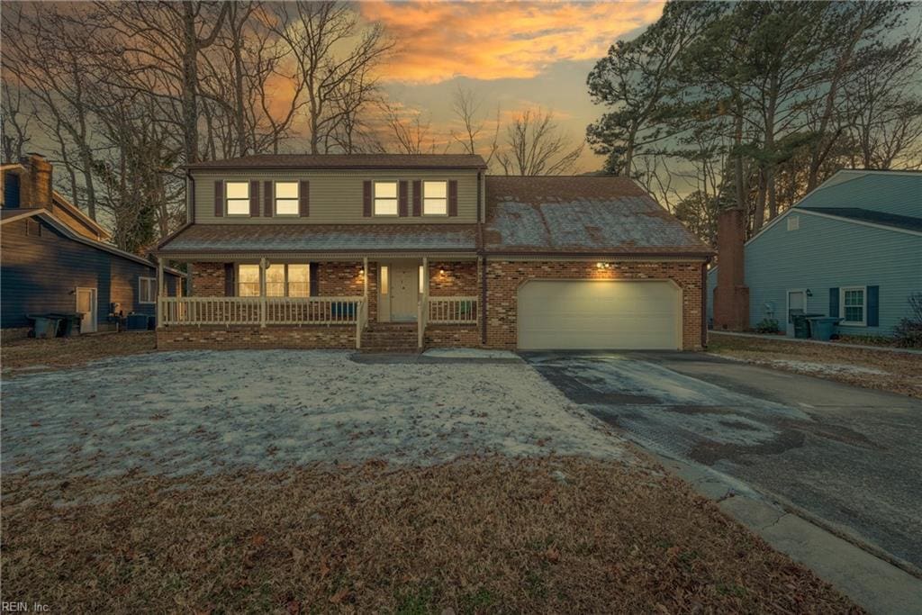 view of front of property featuring central air condition unit, a porch, and a garage