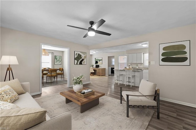 living room featuring ceiling fan, light hardwood / wood-style floors, and plenty of natural light