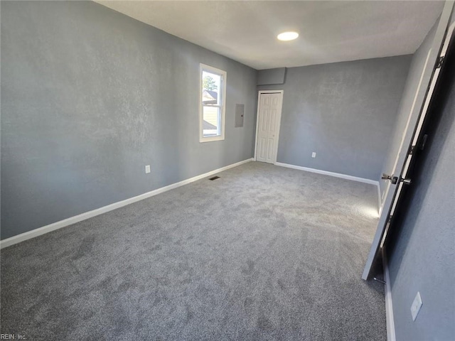 unfurnished room with electric panel and carpet flooring