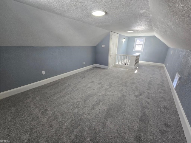 bonus room featuring vaulted ceiling, a textured ceiling, and carpet flooring