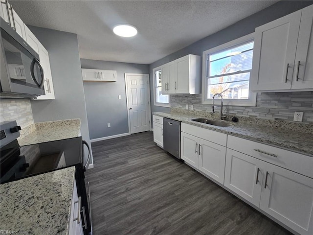 kitchen with electric stove, dishwasher, decorative backsplash, sink, and white cabinetry