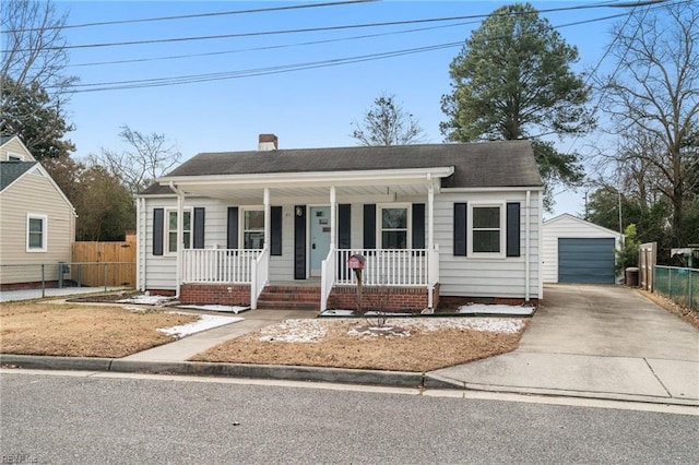 bungalow-style home featuring a porch, a garage, and an outbuilding