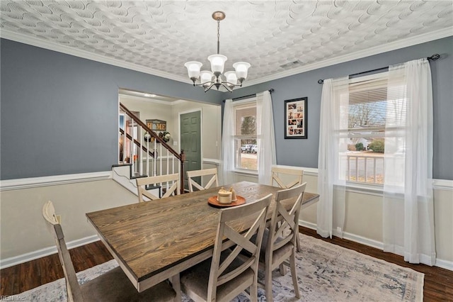 dining room featuring dark hardwood / wood-style floors, crown molding, and a chandelier