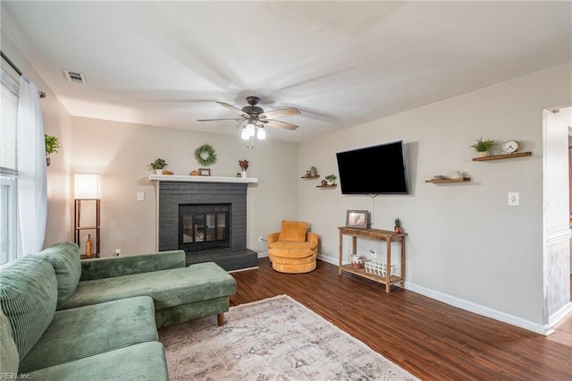 living room with ceiling fan, wood-type flooring, and a fireplace