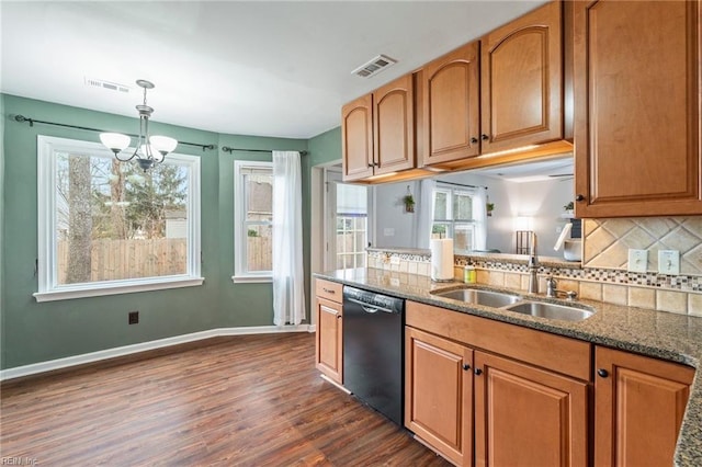 kitchen with decorative light fixtures, dishwasher, dark stone counters, a chandelier, and sink