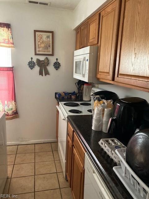 kitchen featuring light tile patterned flooring and white appliances