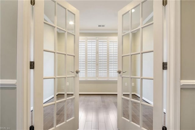 walk in closet featuring french doors and hardwood / wood-style floors