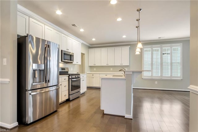 kitchen with appliances with stainless steel finishes, a kitchen island with sink, decorative light fixtures, white cabinets, and sink