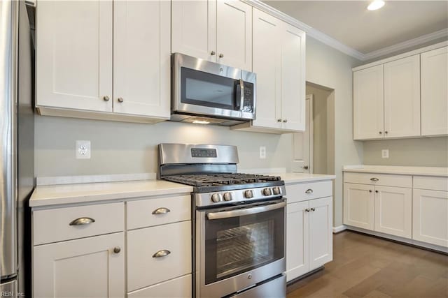 kitchen featuring dark hardwood / wood-style flooring, appliances with stainless steel finishes, ornamental molding, and white cabinetry