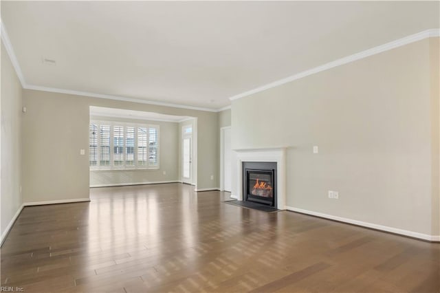 unfurnished living room featuring dark wood-type flooring and crown molding