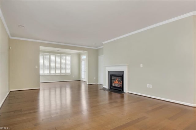 unfurnished living room with ornamental molding and dark hardwood / wood-style floors