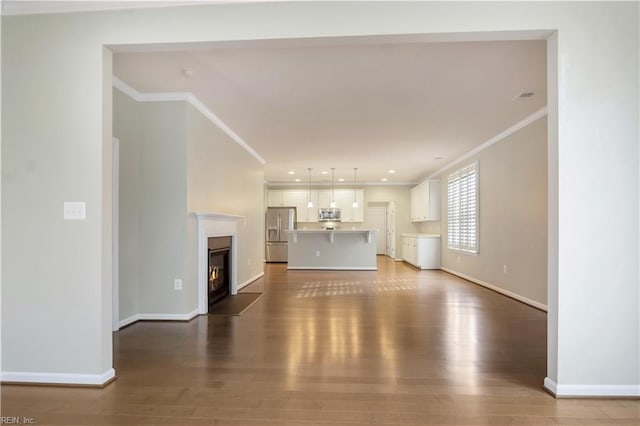 unfurnished living room with ornamental molding and dark hardwood / wood-style floors