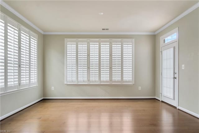 interior space with ornamental molding and hardwood / wood-style floors