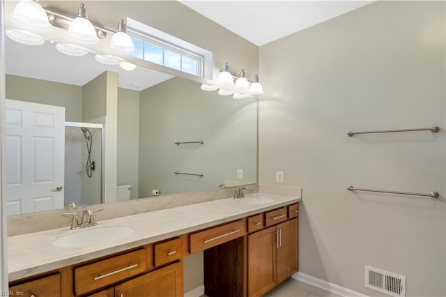 bathroom with tile patterned floors, toilet, vanity, and an enclosed shower