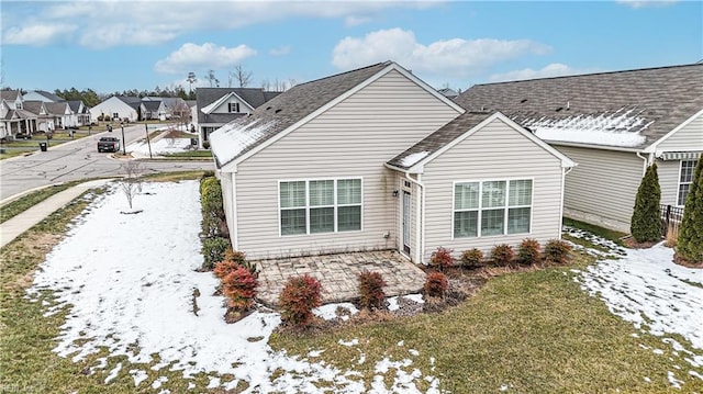 snow covered rear of property with a yard