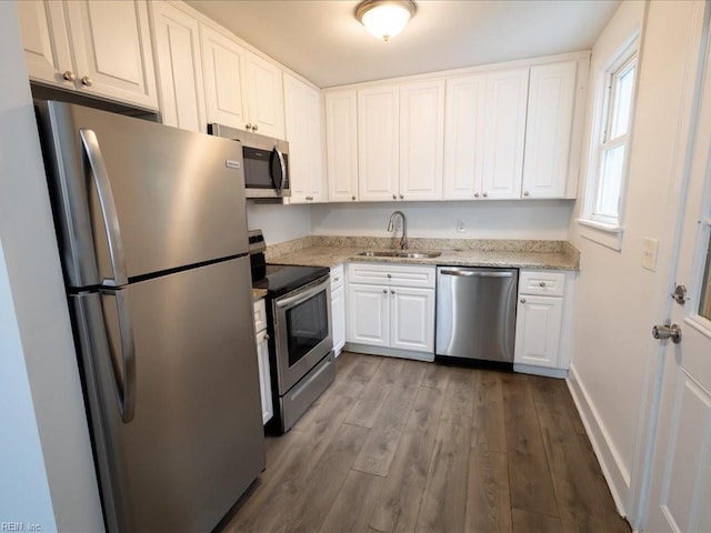 kitchen featuring sink, white cabinetry, light hardwood / wood-style flooring, light stone countertops, and stainless steel appliances