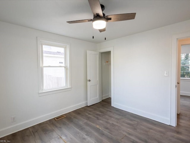 unfurnished room with ceiling fan and dark hardwood / wood-style flooring