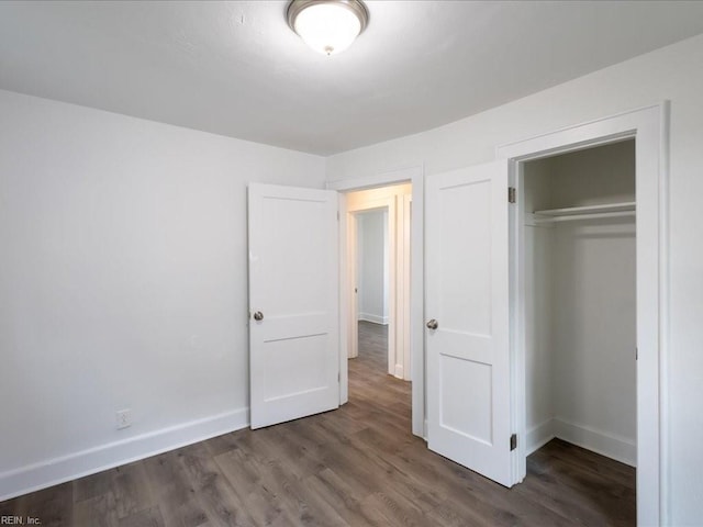 unfurnished bedroom featuring a closet and dark hardwood / wood-style flooring