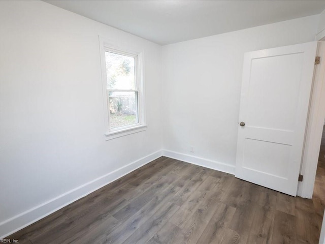 unfurnished room with dark hardwood / wood-style flooring