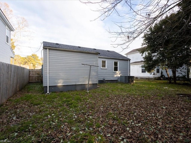 rear view of house featuring a lawn and cooling unit