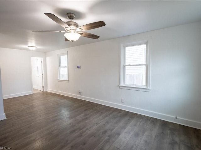 spare room with dark wood-type flooring and ceiling fan