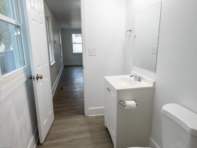 bathroom with hardwood / wood-style floors, toilet, and vanity