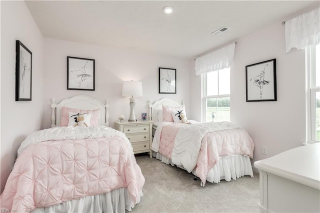 bedroom with visible vents and light carpet