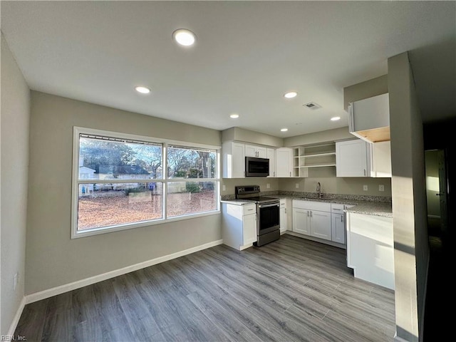 kitchen with appliances with stainless steel finishes, white cabinets, sink, light hardwood / wood-style flooring, and light stone counters