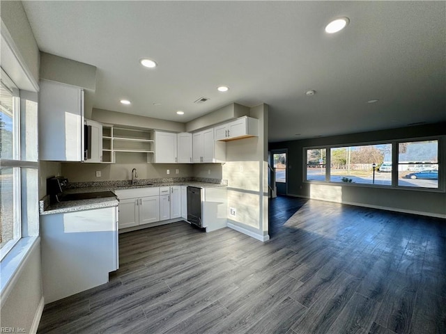 kitchen featuring light stone countertops, sink, white cabinets, and dark hardwood / wood-style floors