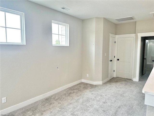 carpeted empty room with plenty of natural light