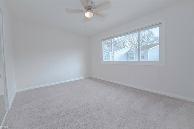 spare room with ceiling fan and light colored carpet