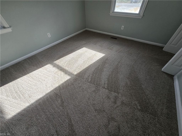 empty room featuring dark carpet