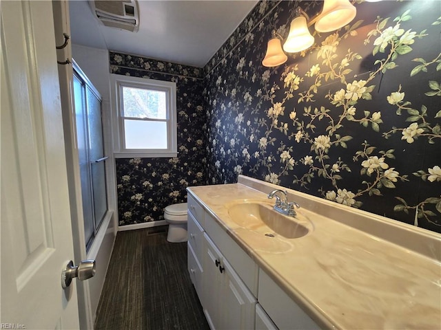 full bathroom with toilet, bath / shower combo with glass door, wood-type flooring, and vanity