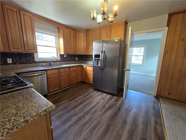 kitchen featuring an inviting chandelier, stainless steel appliances, decorative light fixtures, dark hardwood / wood-style flooring, and sink