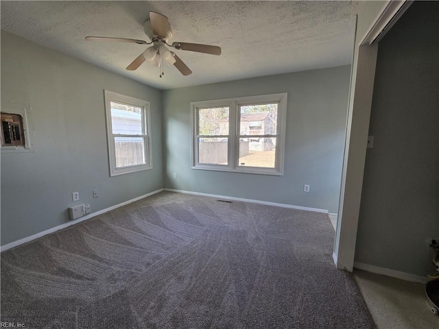 carpeted empty room featuring a textured ceiling and ceiling fan