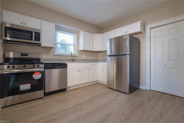 kitchen featuring light hardwood / wood-style flooring, sink, stainless steel appliances, and white cabinetry