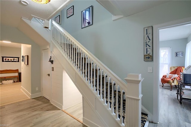 stairway featuring a textured ceiling and hardwood / wood-style floors