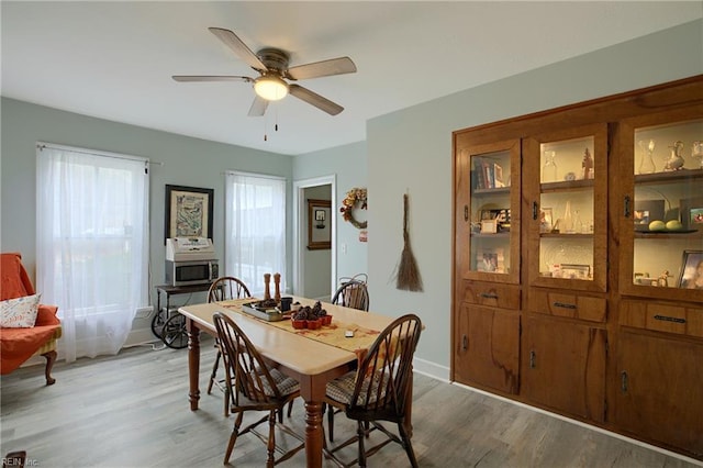 dining room with ceiling fan and light wood-type flooring