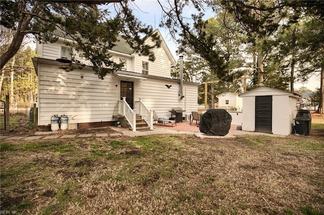 back of house with a patio, a lawn, and a storage unit