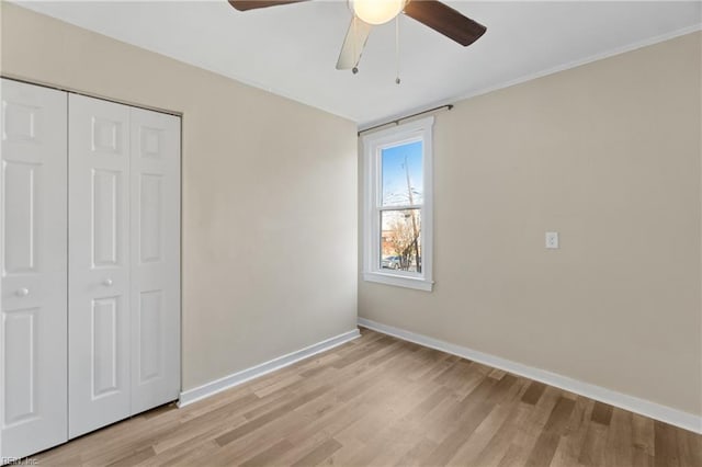 unfurnished bedroom with ceiling fan, a closet, and light wood-type flooring