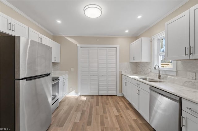 kitchen with stainless steel appliances, light hardwood / wood-style floors, white cabinets, and sink