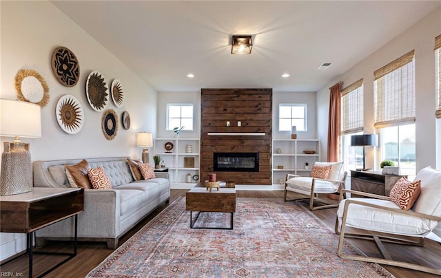 living room featuring dark wood-type flooring and a fireplace