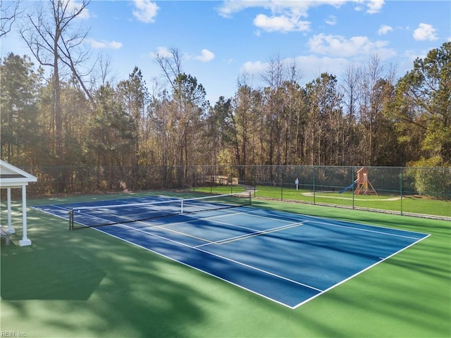 view of tennis court featuring a playground