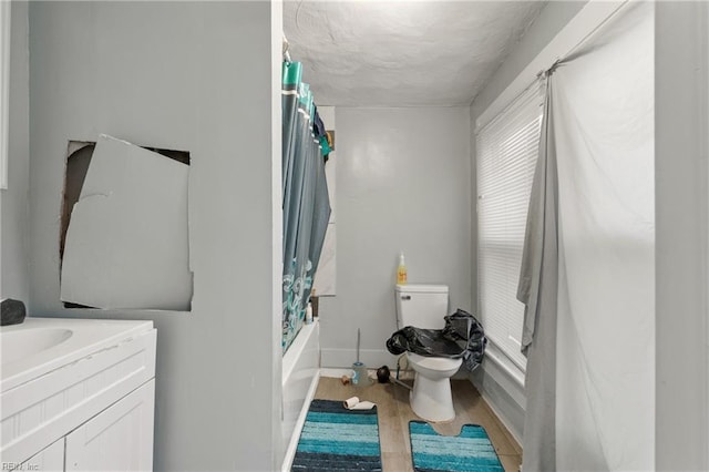 full bathroom with toilet, vanity, wood-type flooring, and shower / bathtub combination with curtain