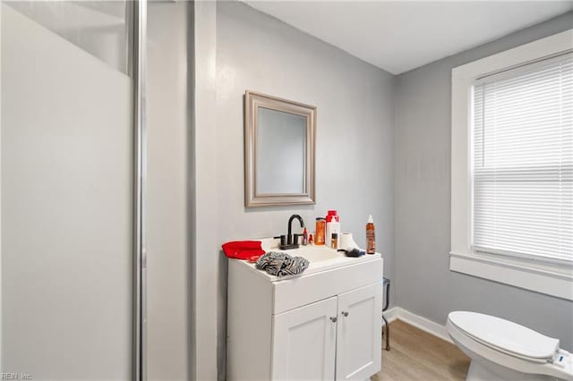 bathroom featuring plenty of natural light, hardwood / wood-style floors, toilet, and vanity