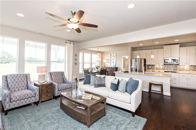 living room with ceiling fan and dark hardwood / wood-style flooring